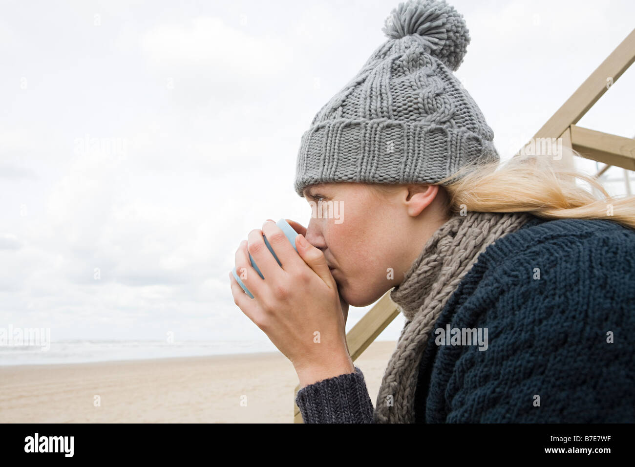 Young woman by the sea with drink Stock Photo - Alamy
