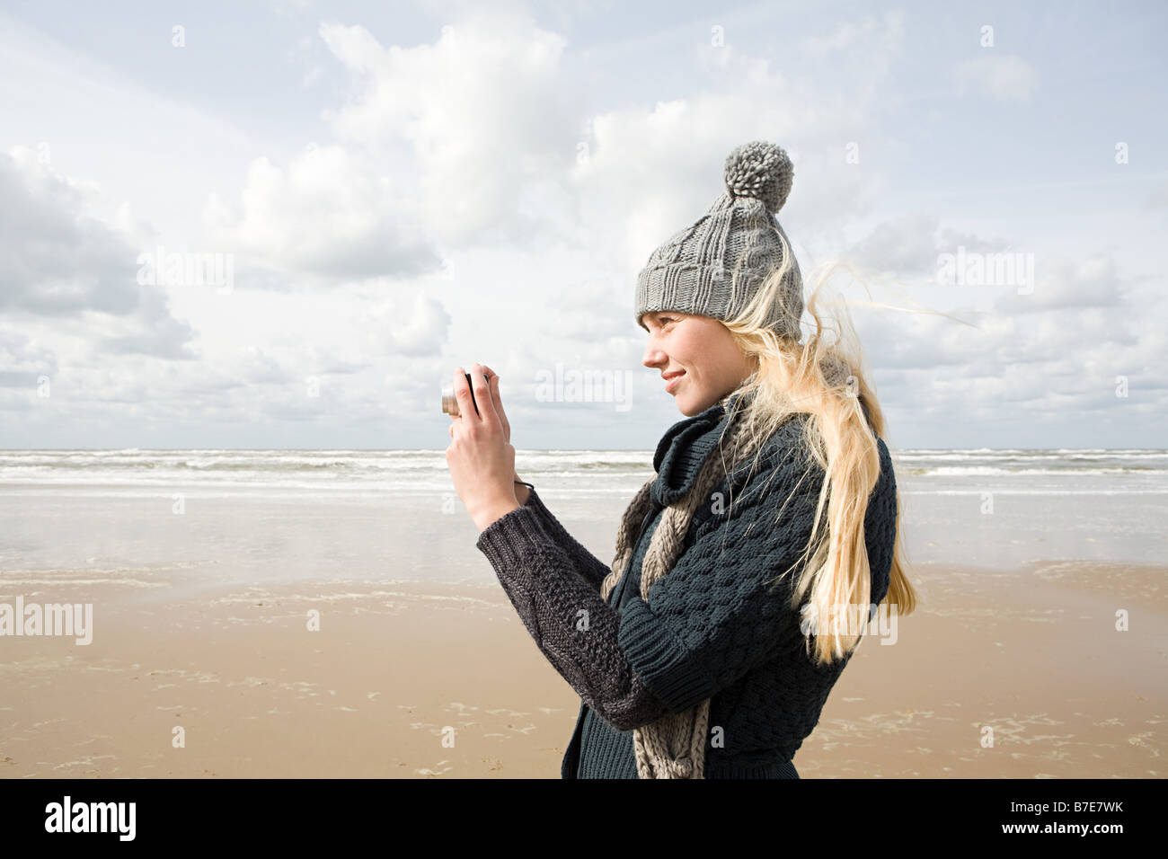 Woman by the sea with camera Stock Photo - Alamy