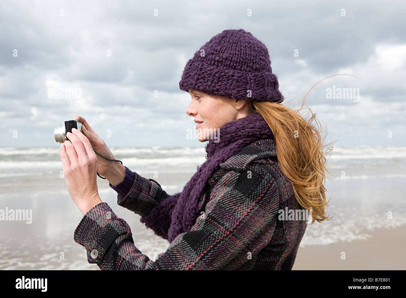 Woman by the sea with camera Stock Photo - Alamy