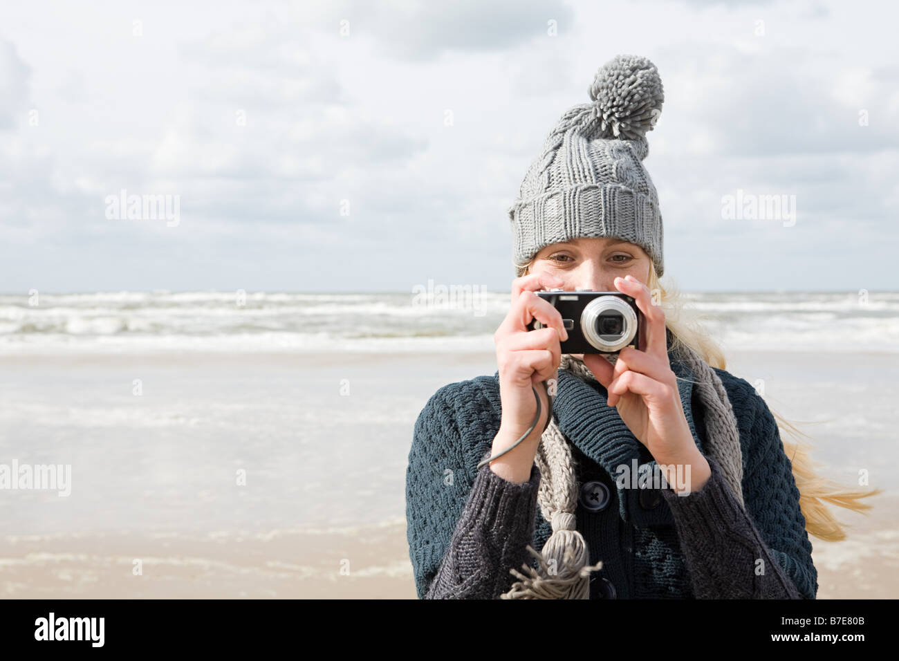 Woman by the sea with camera Stock Photo - Alamy
