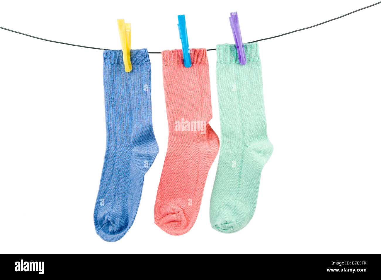 A blue pink and green sock hanging on a line Stock Photo