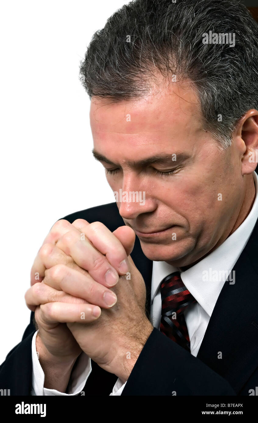 Man with hands folded and head bowed in a posture of prayer Stock Photo