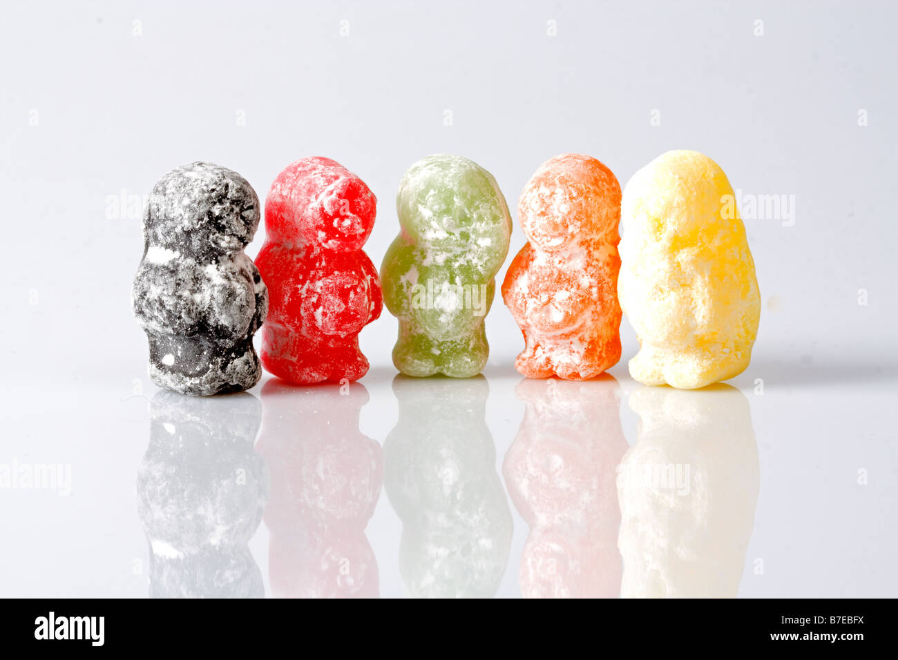 Line of jelly babies in different colours with mirror reflection Stock