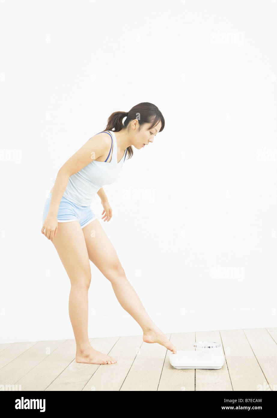 Woman getting on the scale Stock Photo