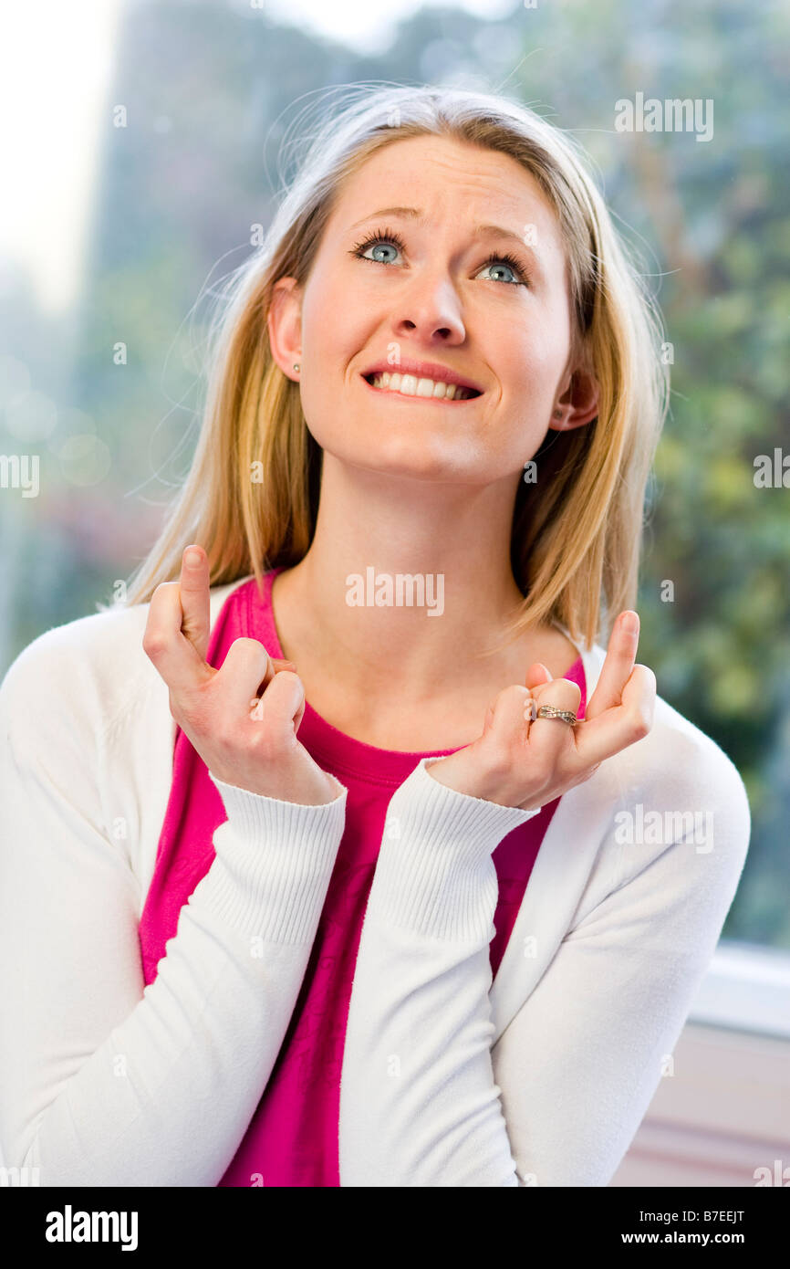 Woman with fingers crossed Stock Photo - Alamy