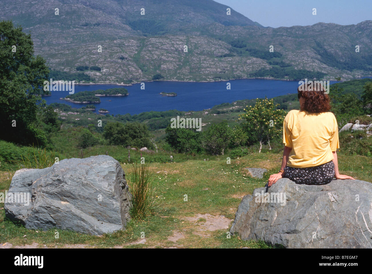 Person sitting on rock hi-res stock photography and images - Alamy