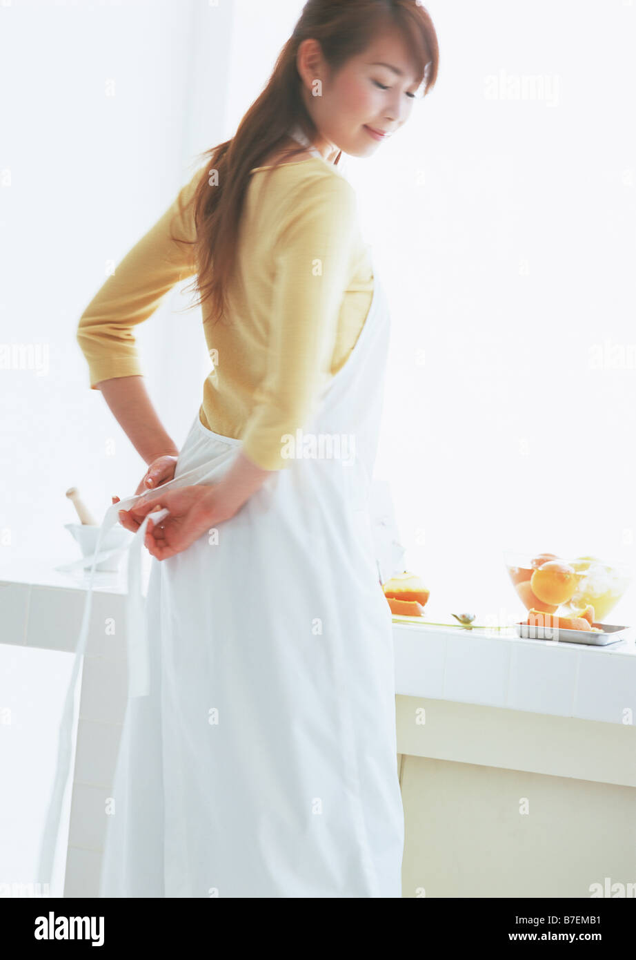 Woman tying apron strings Stock Photo Alamy