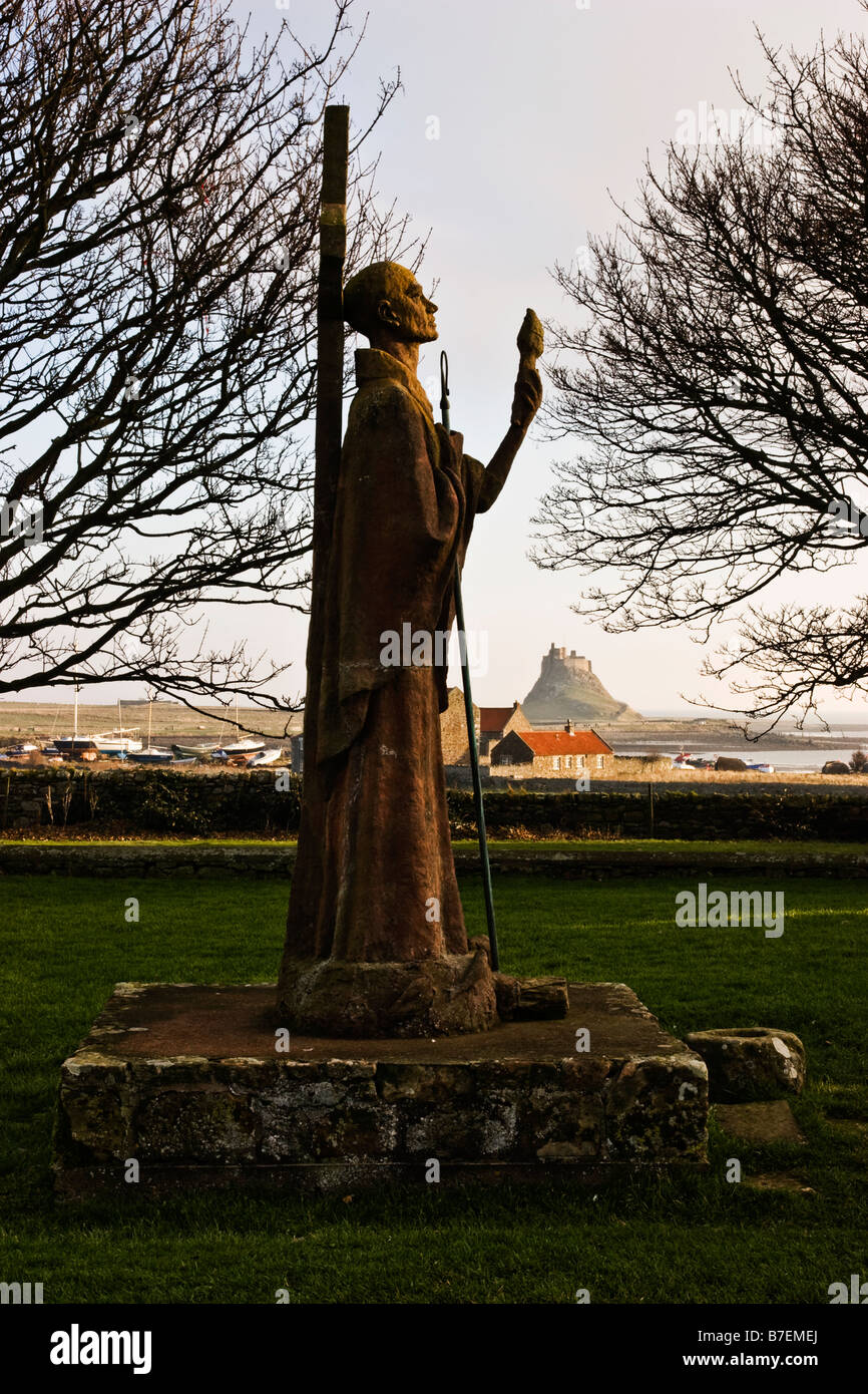 Statue of Saint Aidan at Lindisfarne Priory with Lindisfarne Castle in Background Stock Photo