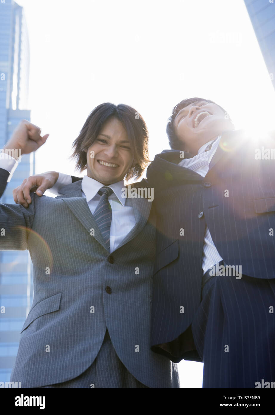 Businessmen with arms around shoulder Stock Photo