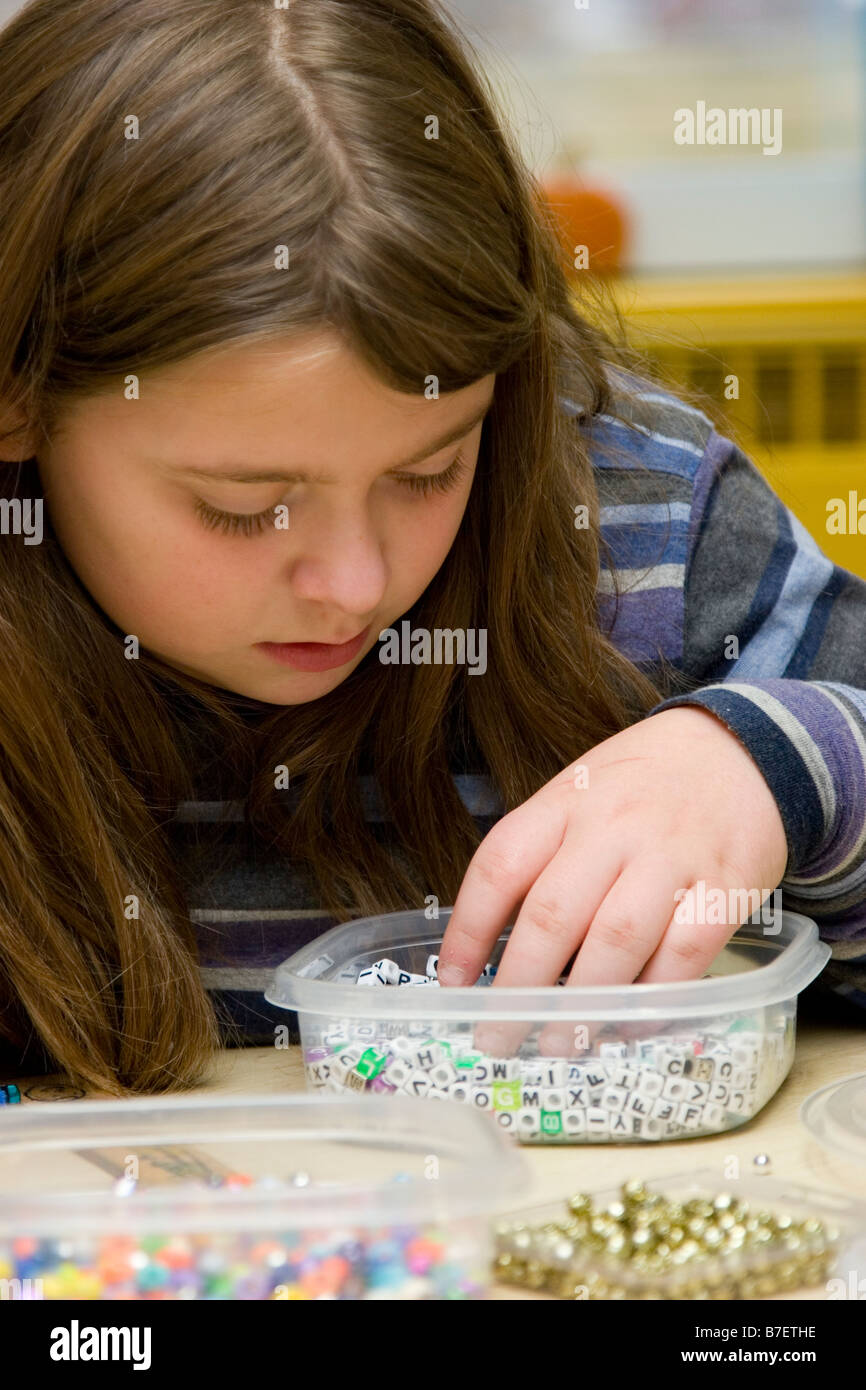 Young girl works with beads beading Stock Photo