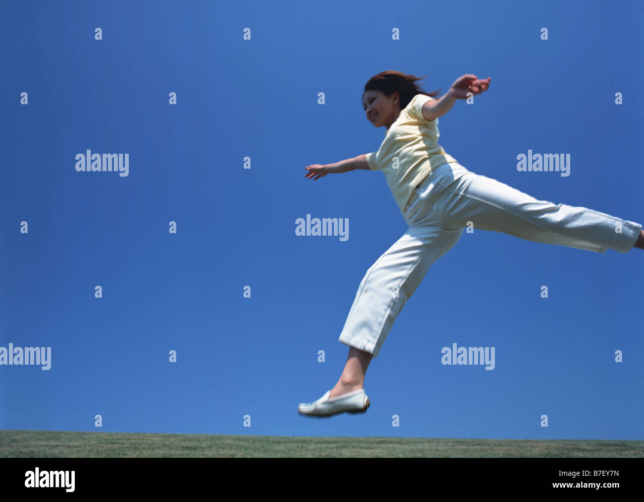 Woman jumping up in field Stock Photo Alamy