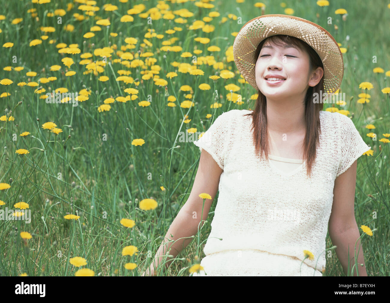 Woman sitting in flower garden Stock Photo - Alamy