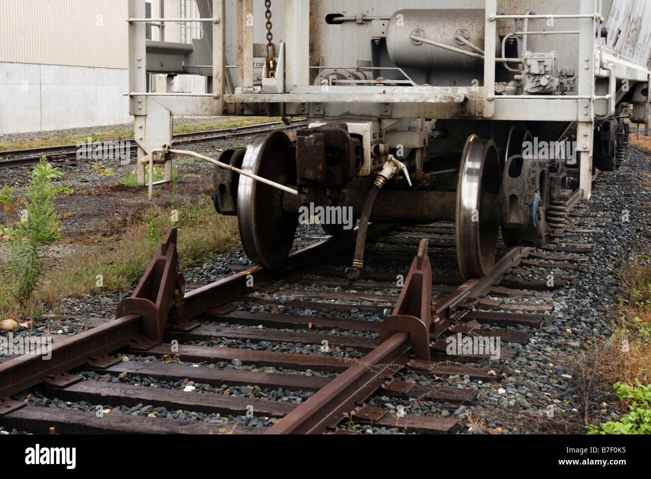 Freight car and wheel stops on track in rail yard Stock Photo Alamy