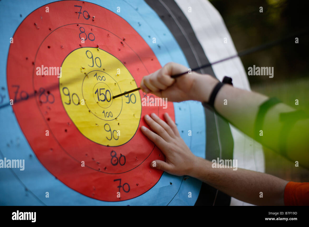 Man practising Archery at Carew Castle Archery Target with Arrows in Bull s Eye Stock Photo