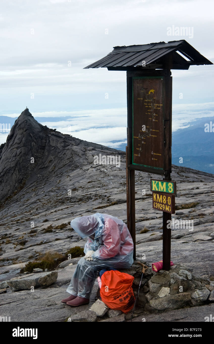 Tired woman despairs of reaching the top of Mount Kinabalu in Borneo, Malaysia Stock Photo