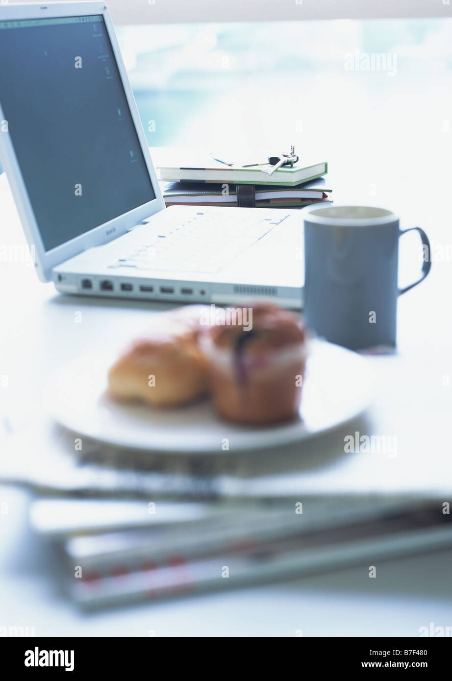 Laptop,  muffins and personal belongings Stock Photo