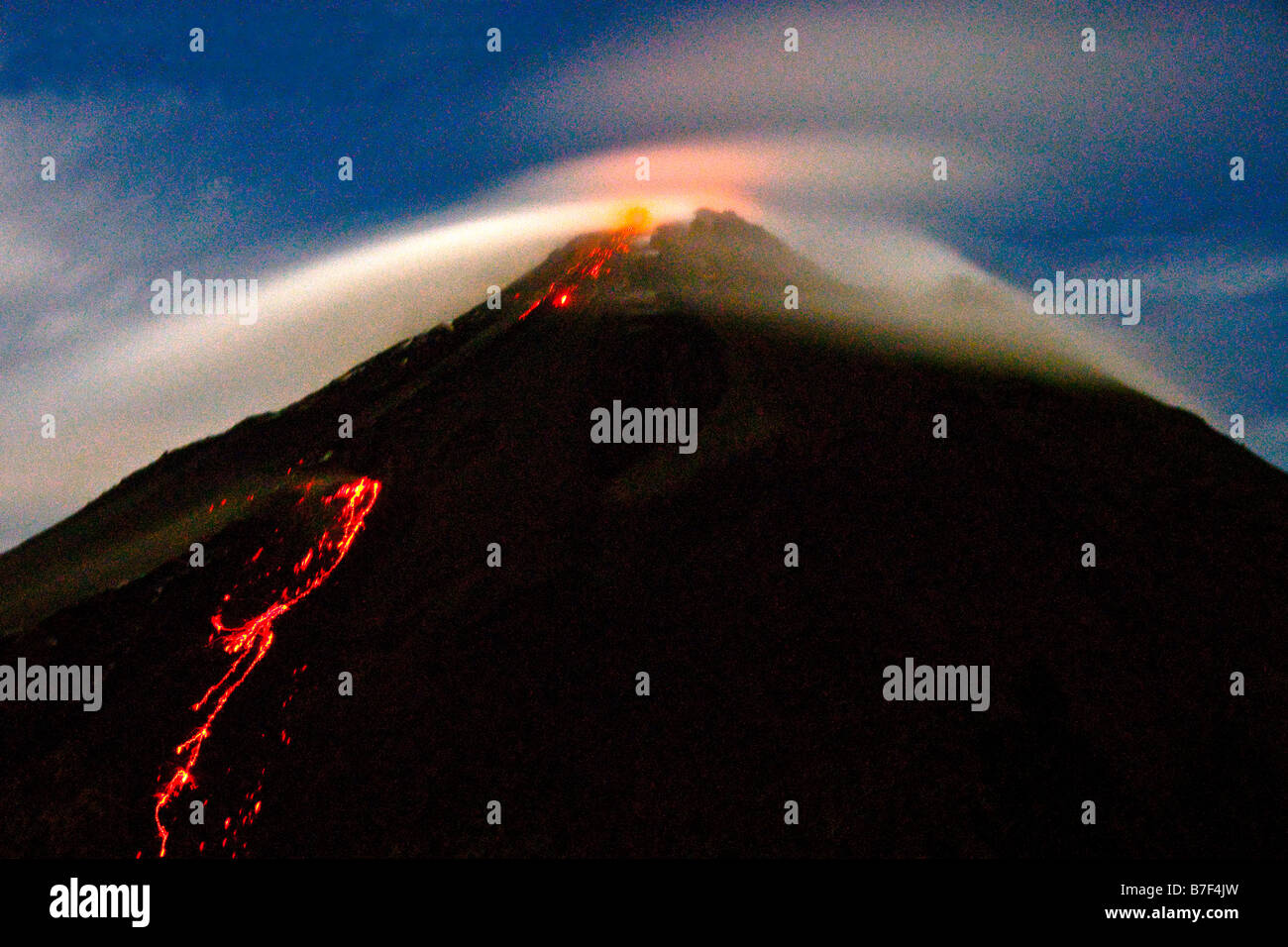 Arenal Volcano emitting smoking lava and incandescent pyroclastic flows at night Stock Photo