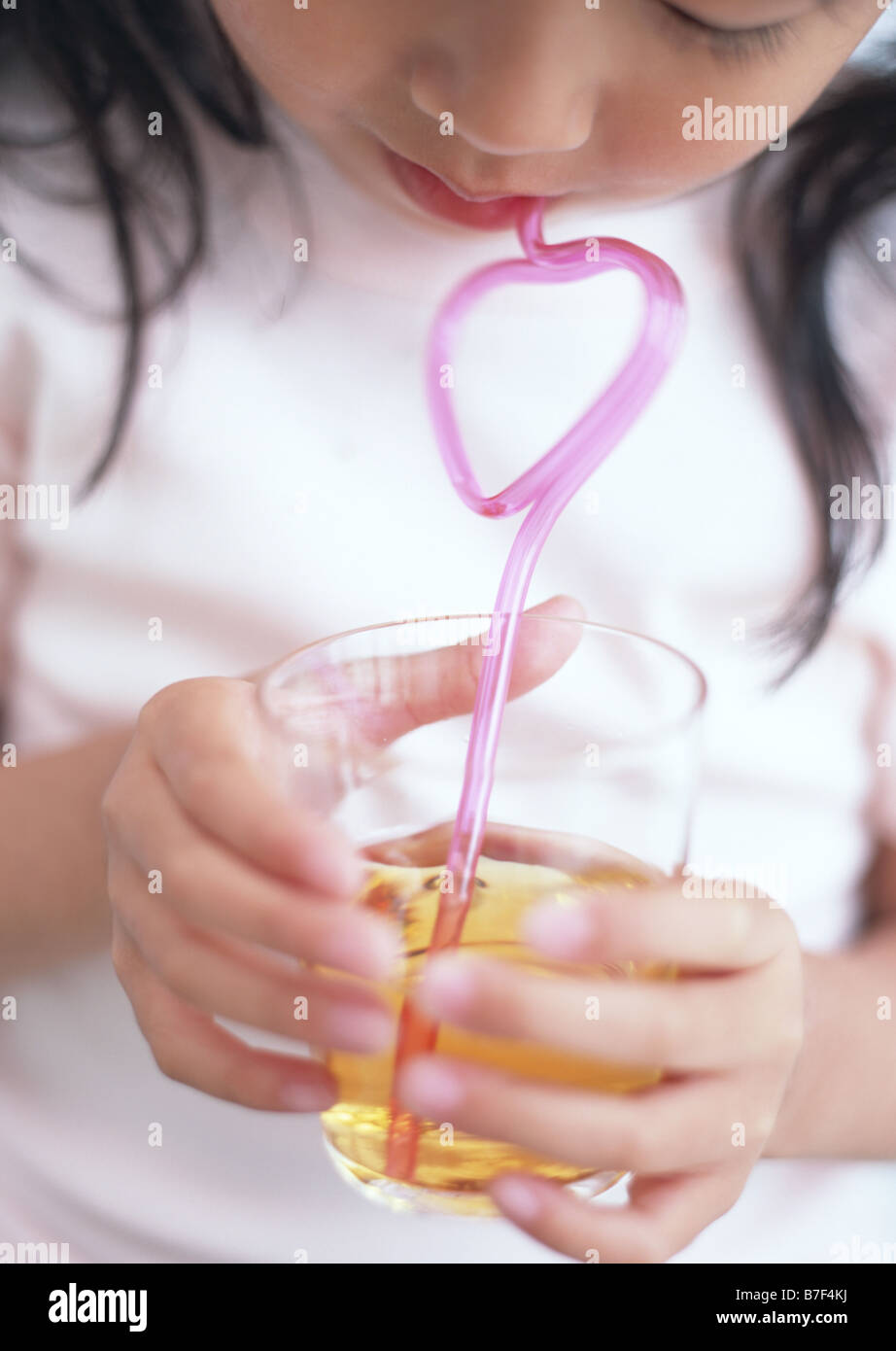 Girl drinking juice with straw Stock Photo Alamy