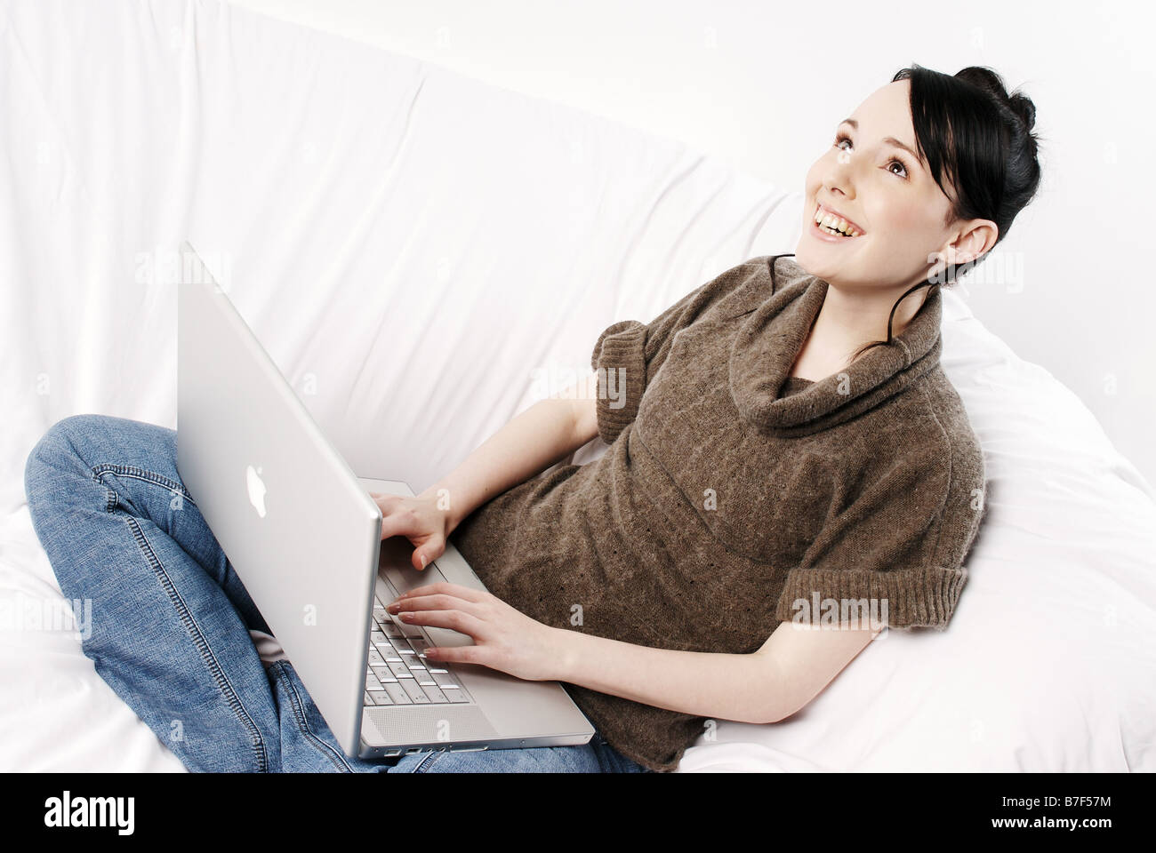 Young woman sitting on a sofa using a laptop computer Stock Photo - Alamy