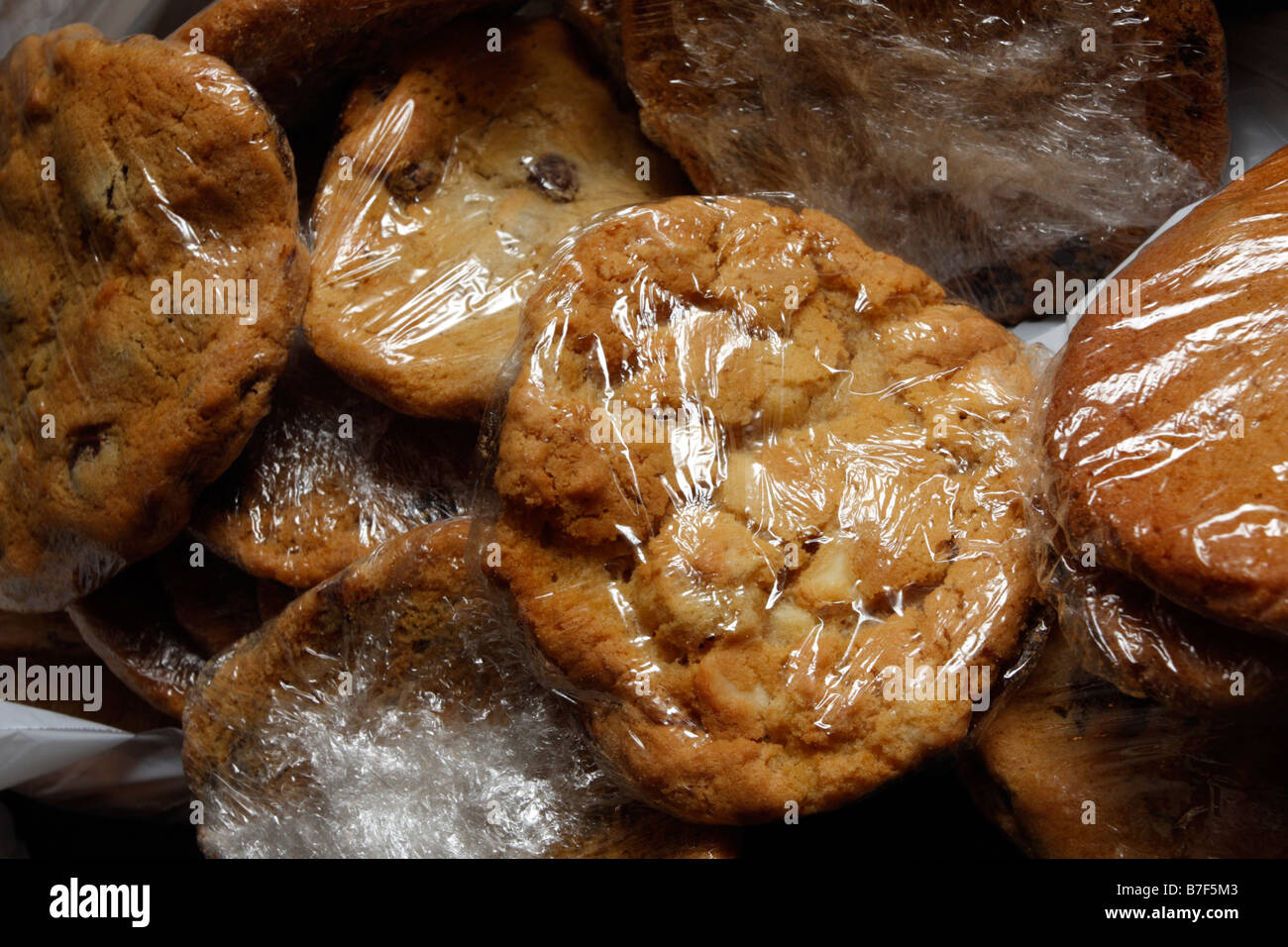 Plain chocolate-chip cookies, sugary and wrapped in plastic Stock Photo