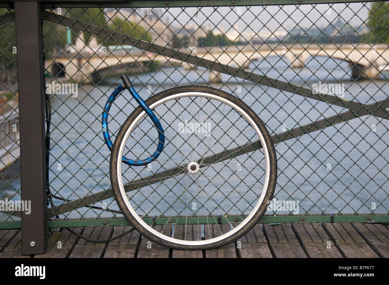 Bicycle wheel locked on a bridge in Paris Stock Photo