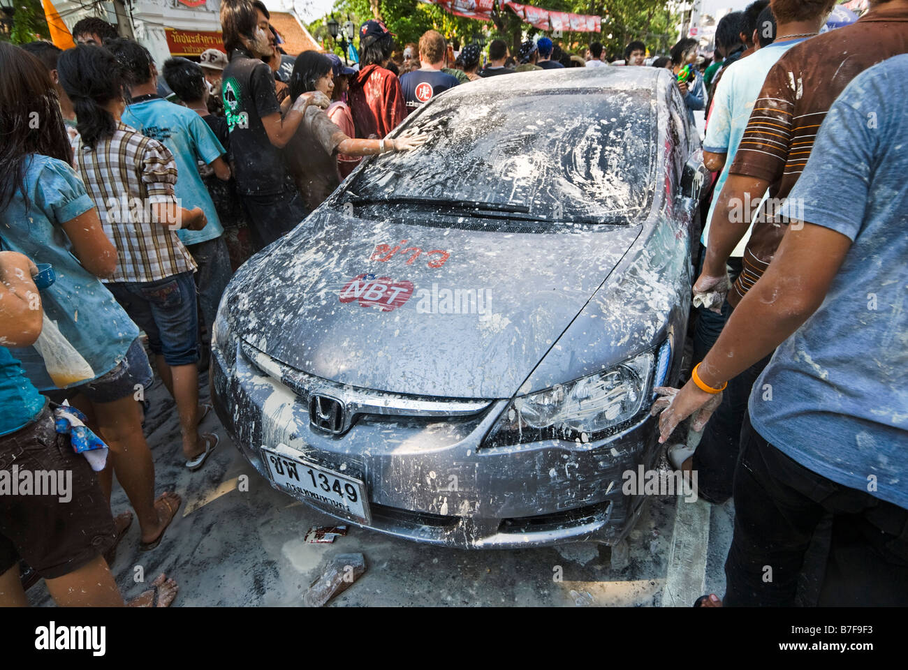 Car trying to pass through young people celebrating the Thai new year of Songkran - Banglamphu Bangkok Thailand Stock Photo
