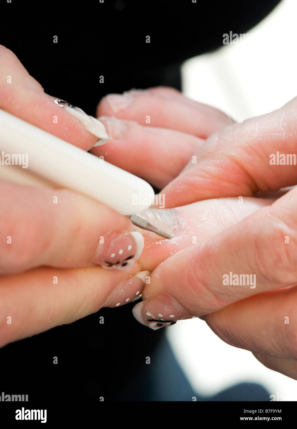Foot therapist working on a pair of feet removing dead tissue around the nail Stock Photo
