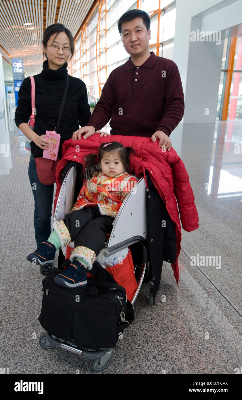 Chinese family at airport travelling at Chinese new year with single baby daughter 2009 Stock Photo