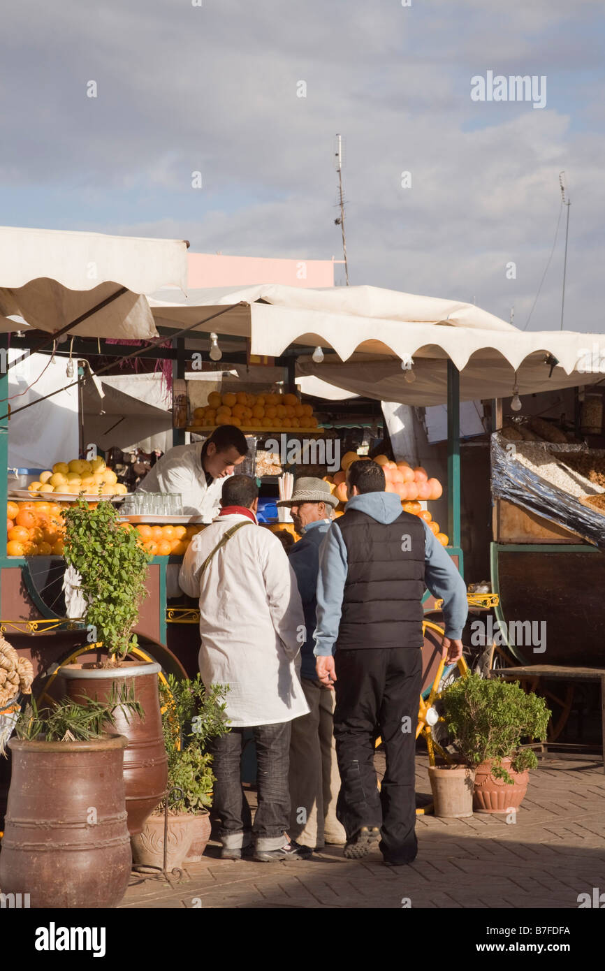 Marrakech Morocco North Africa Local people buying fruit at stall in Place Djemma el Fna square in the Medina Stock Photo