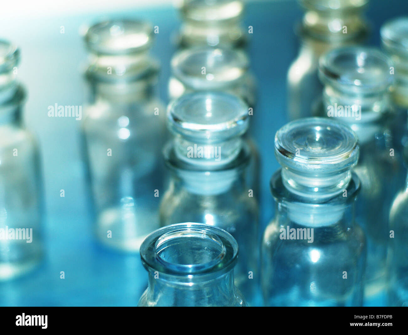 Small glass medicine bottles on blue background Stock Photo Alamy