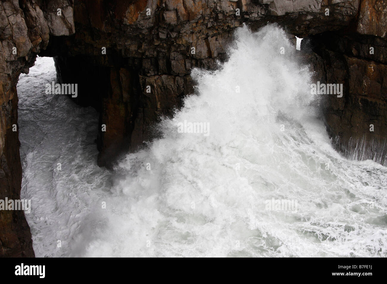 Powerful white waves crashing against rocky cliffs, Pembrokeshire Coast, Wales, UK Stock Photo