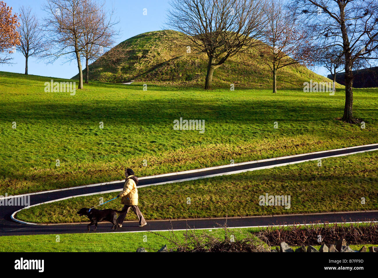 woman walking dog beside Dundonald mound, Belfast, Ireland Stock Photo