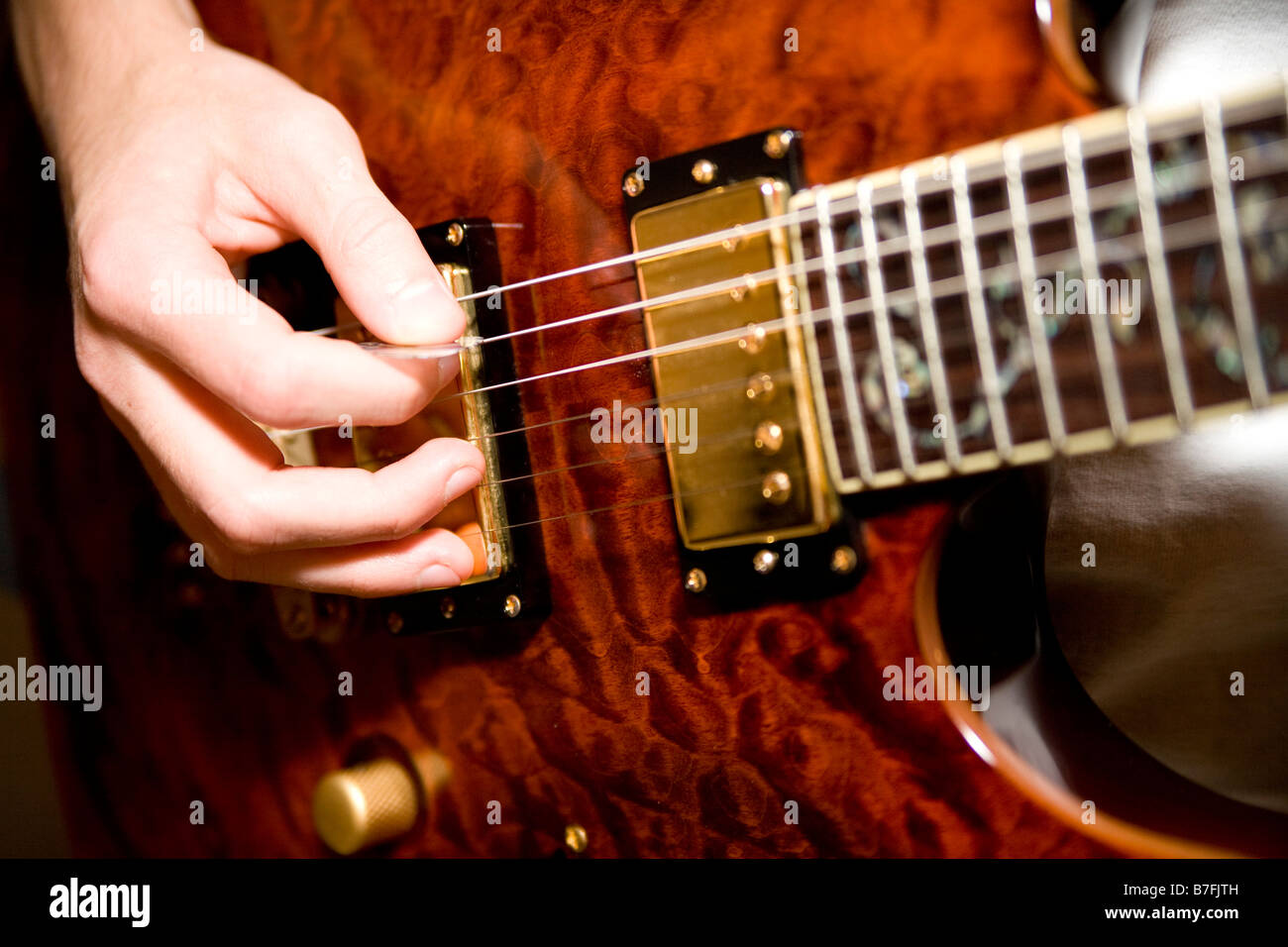 Electronic pickups on electric guitar carry sound to amplifier Stock