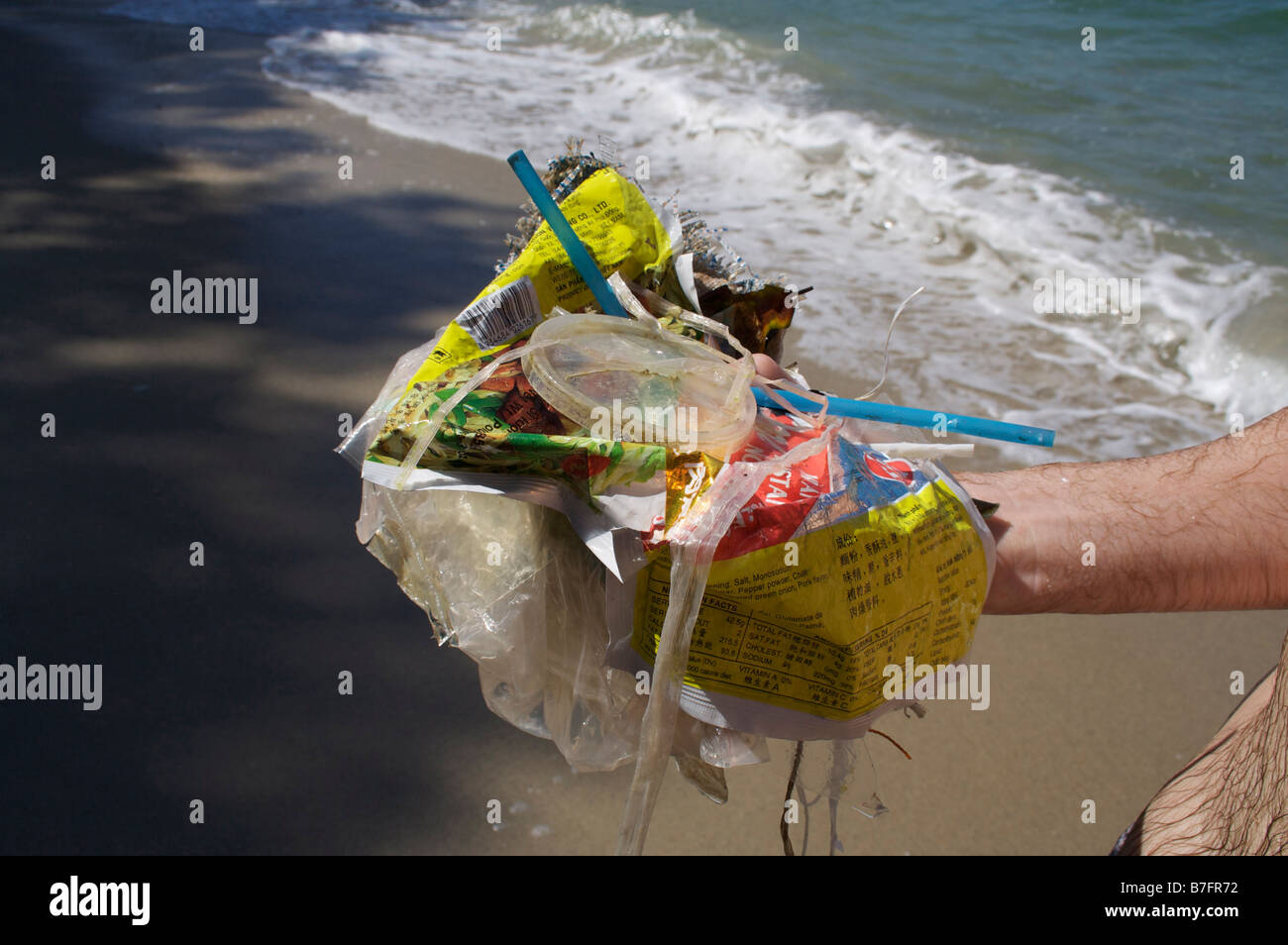 Man holding rubbish collected from the sea during a swim. Stock Photo