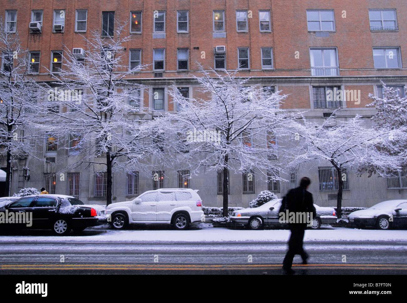 New York City Apartment Building Winter Snow Man Crossing Slushy Street USA Stock Photo