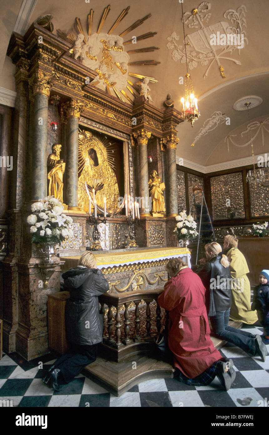 Polish pilgrims praying at Madonna of Gate of Dawn icon in Vilnius Lithuania Stock Photo