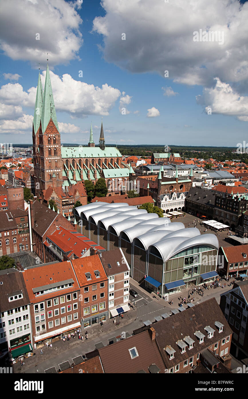 Church Marienkirche and town market square with modern shops among old buildings Lubeck Germany Stock Photo