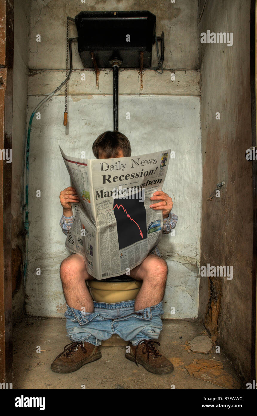 Man sitting on a very dilapidated toilet reading newspaper about the recession. Stock Photo