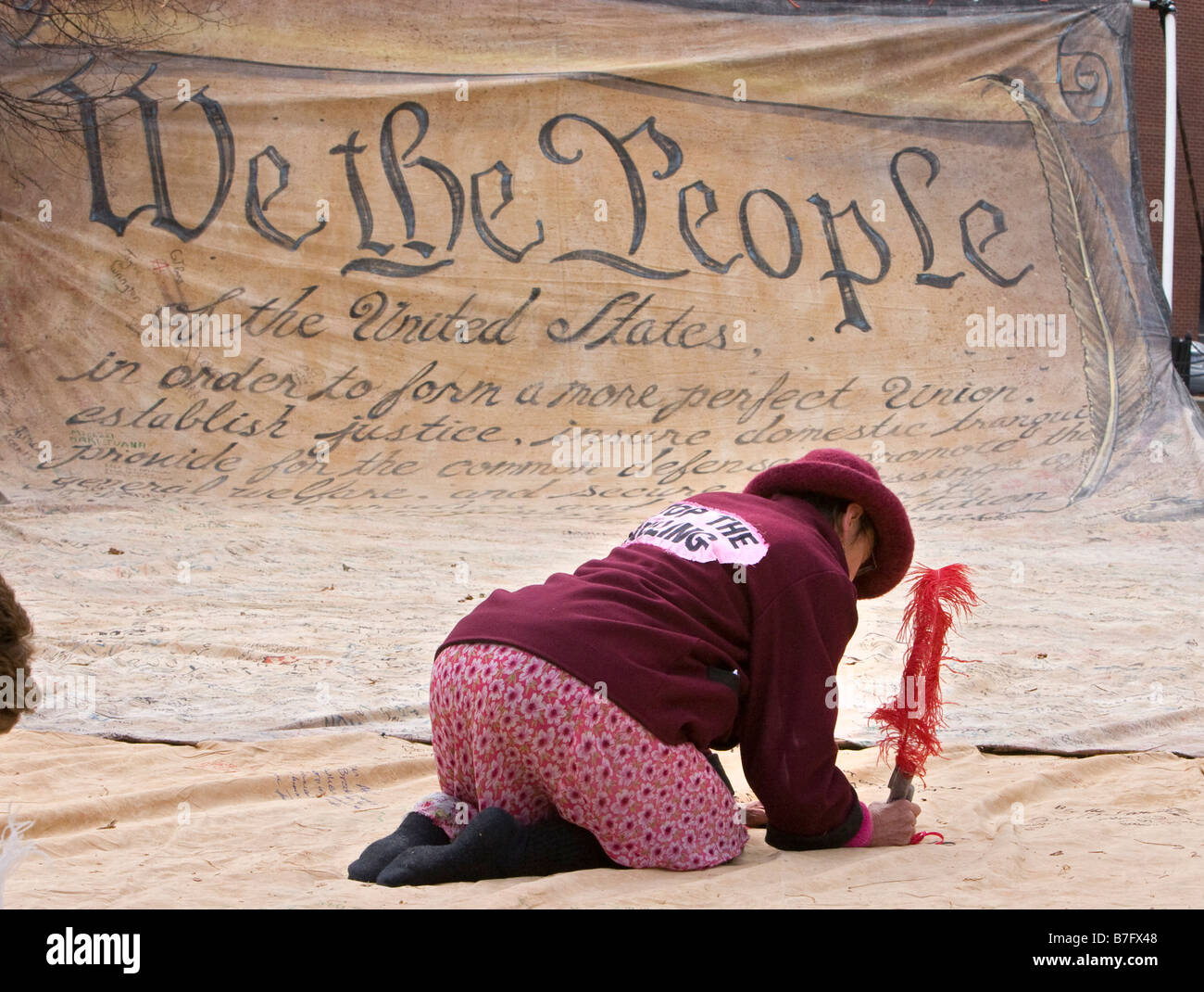 Woman Signs Name to Replica of Preamble to US Constitution Stock Photo
