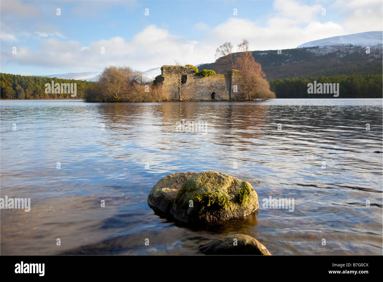 Lochside ruined historic 13th century island castle, forest and hill at freshwater Loch an Eilein, Craig Dubh, Rothiemurchus, Aviemore, Scotland, UK Stock Photo