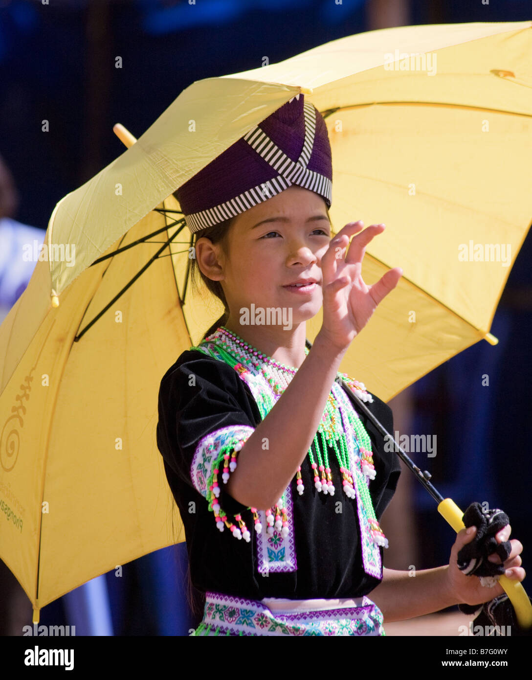 A young Hmong girl in traditional dress prepares to catch a ball at a ...