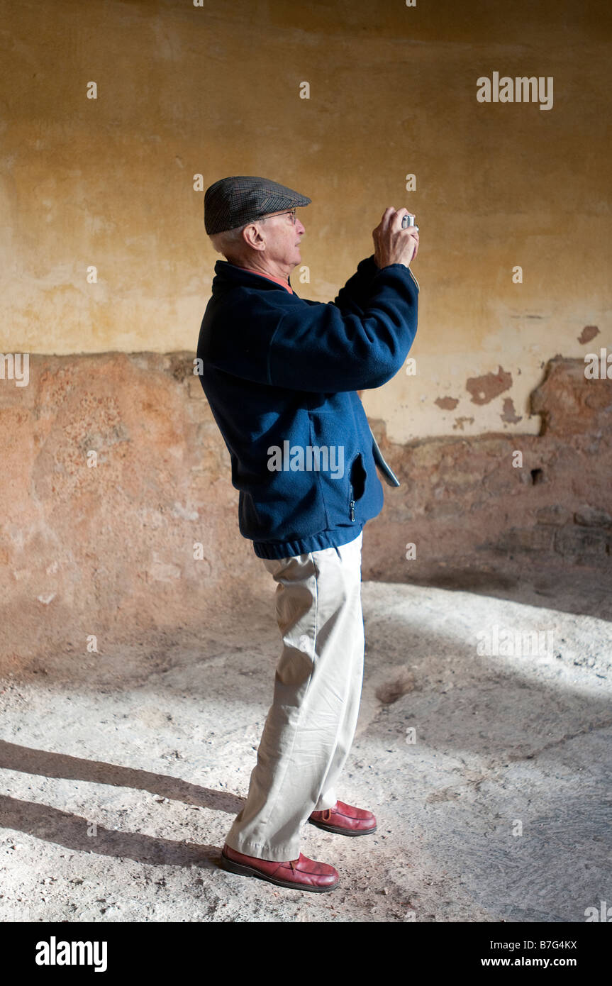 A tourist at the Roman baths in Bath, UK taking a photograph Stock Photo