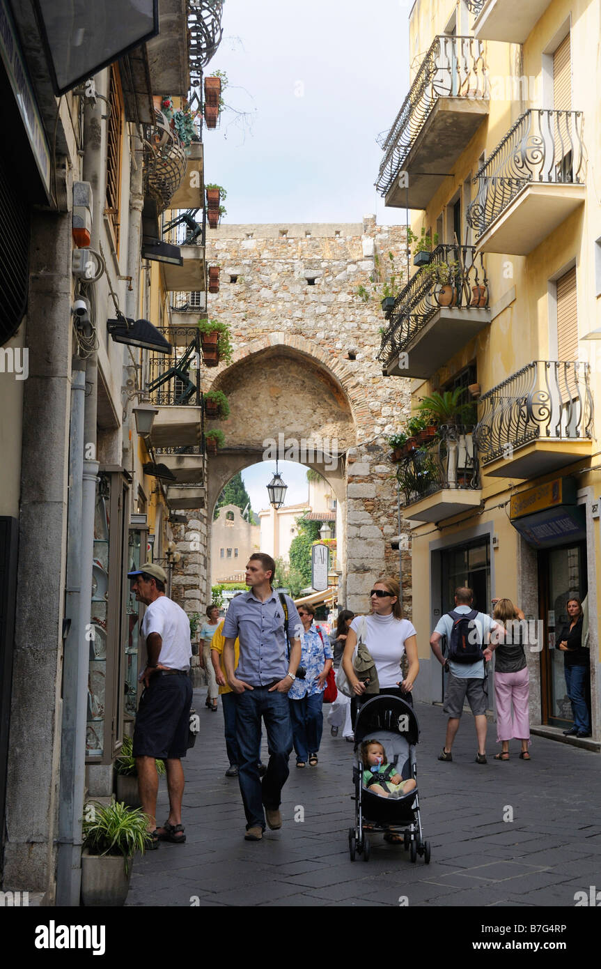 Arch through town walls on the Main shopping street of Taormina, Sicily, Italy Stock Photo
