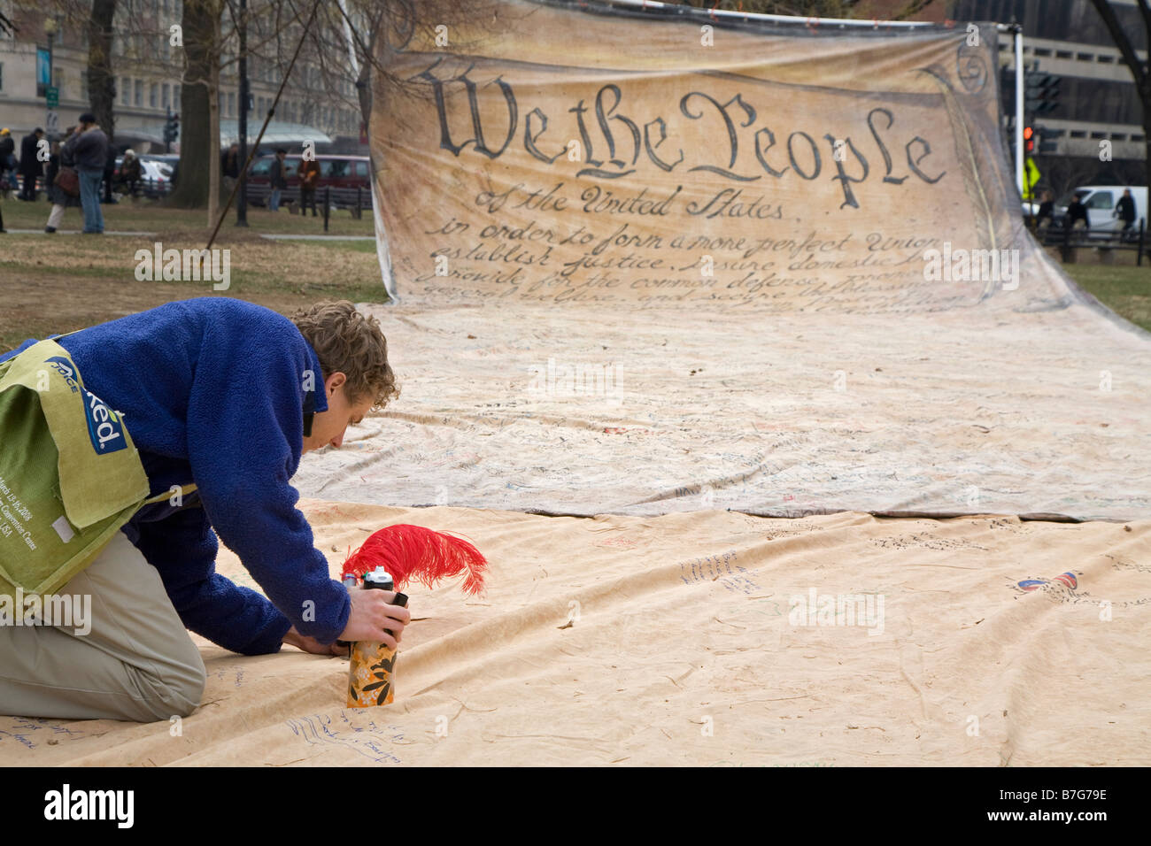 Person Signs Name to Replica of Preamble to US Constitution Stock Photo