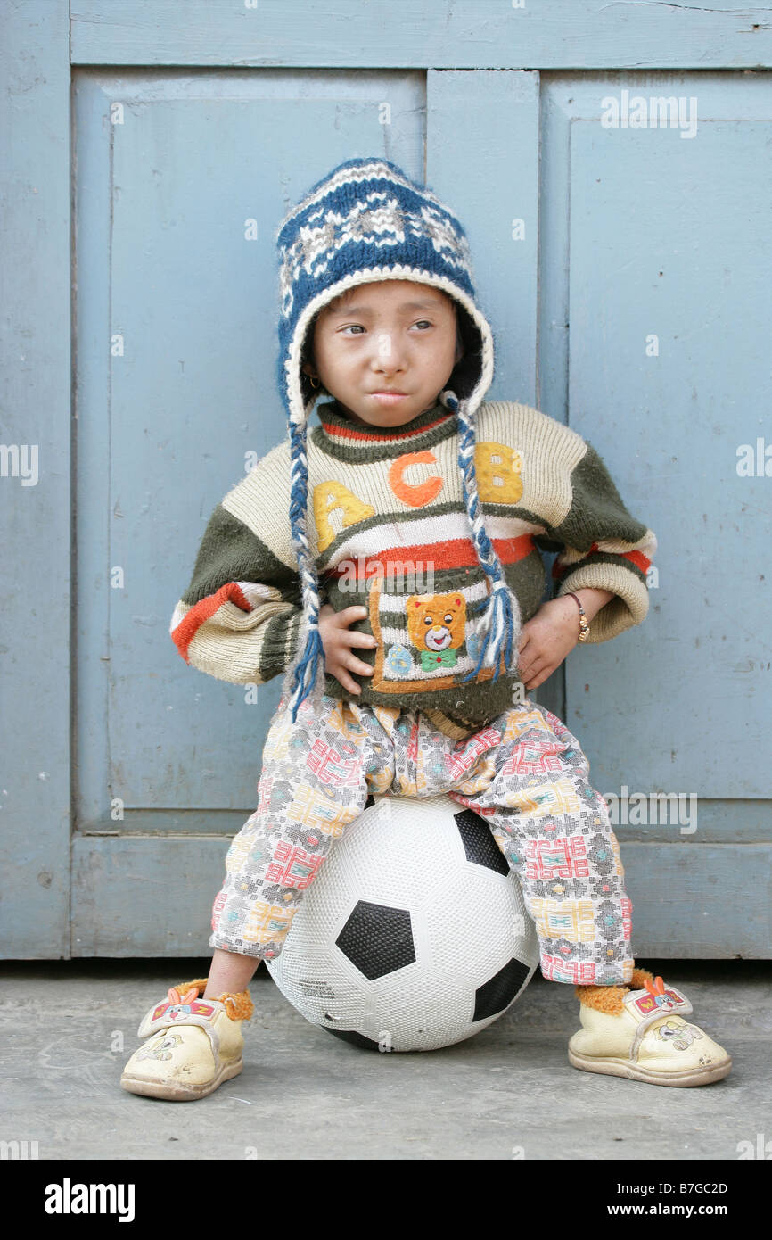 Eighteen year old Khagendra Thapa Magar the worlds smallest man sat on a football Stock Photo