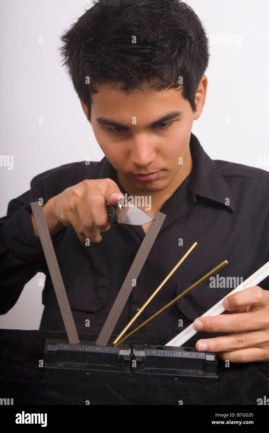 A young Asian American man sharpening his knife Stock Photo Alamy