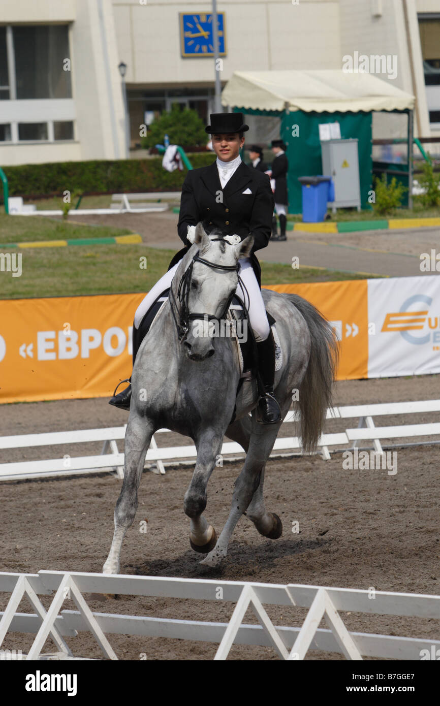 Lady rider trotting on a grey horse in sport arena Stock Photo - Alamy