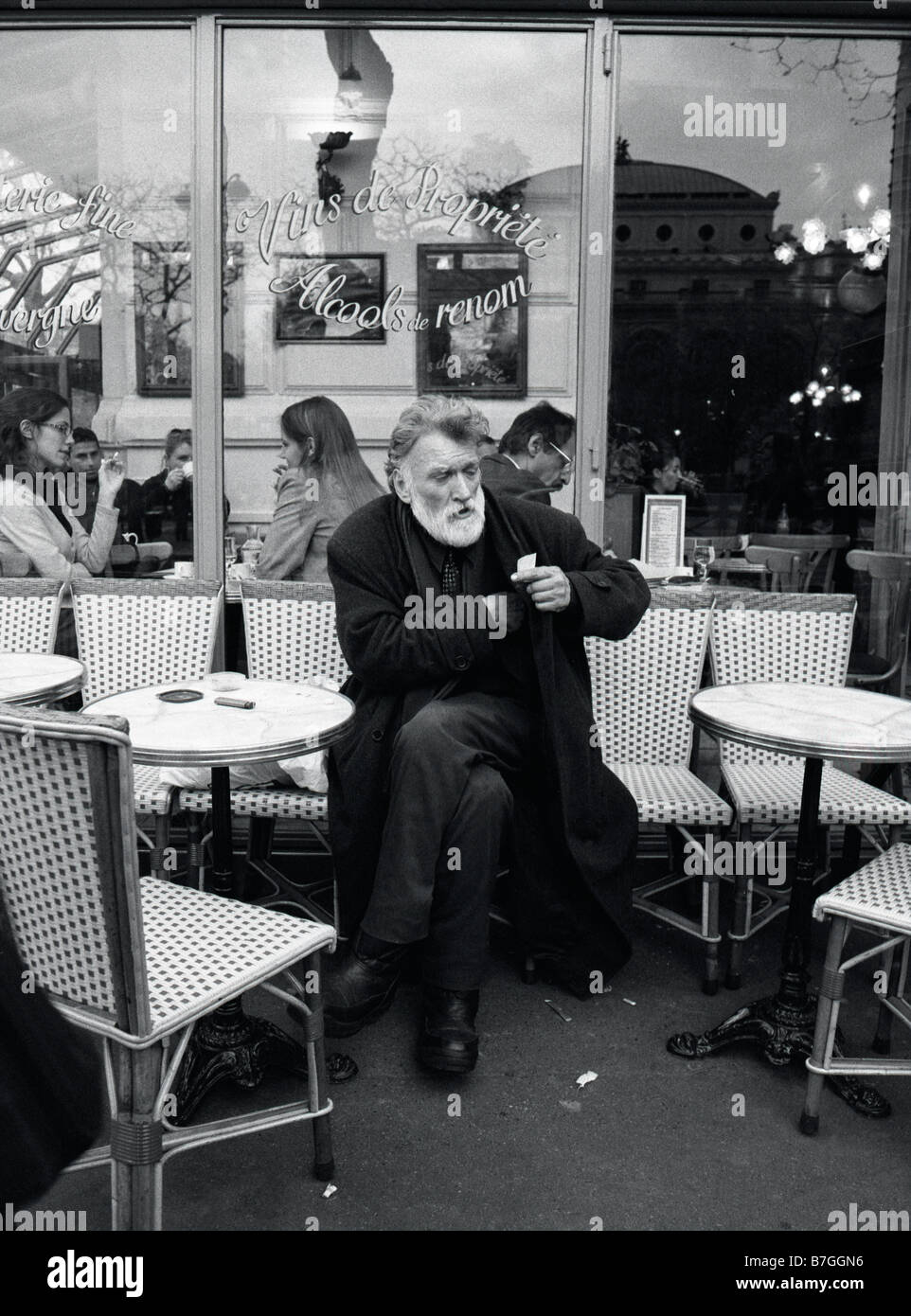 Paris, France. Man rolling cigarette outside cafe Stock Photo