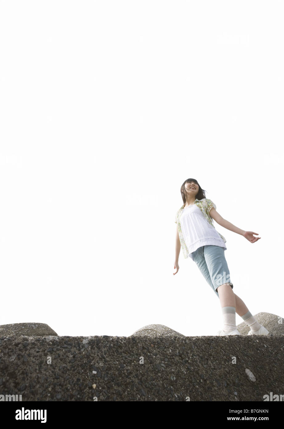 Girl walking along a seawall Stock Photo - Alamy