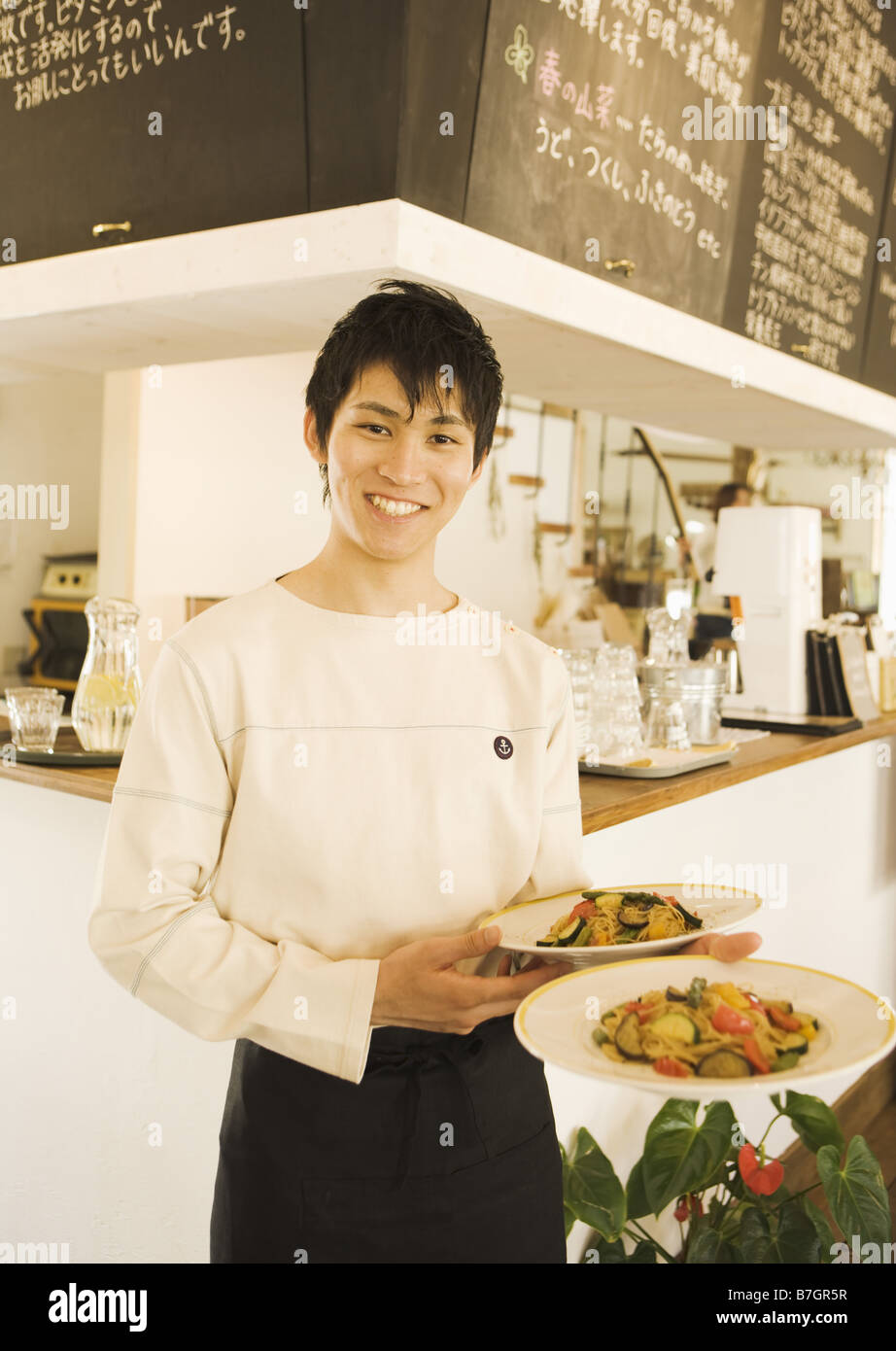 Waiter carrying plates of food Stock Photo Alamy
